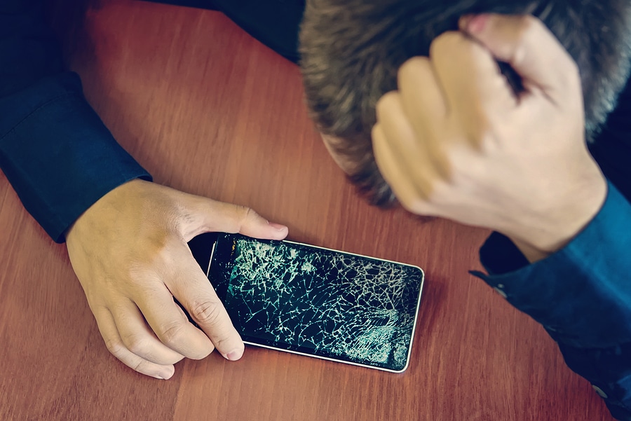 Photo of a frustrated person with a broken phone