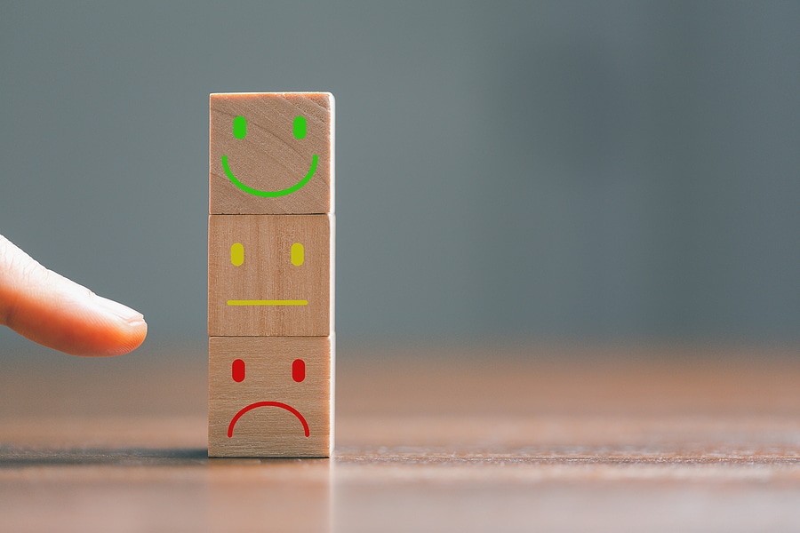 Image of a finger pointing at a frowning face