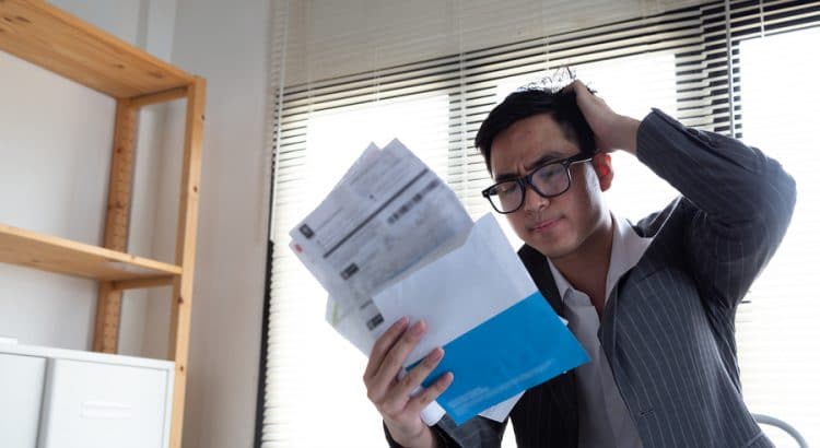 Picture of a confused person looking at bills